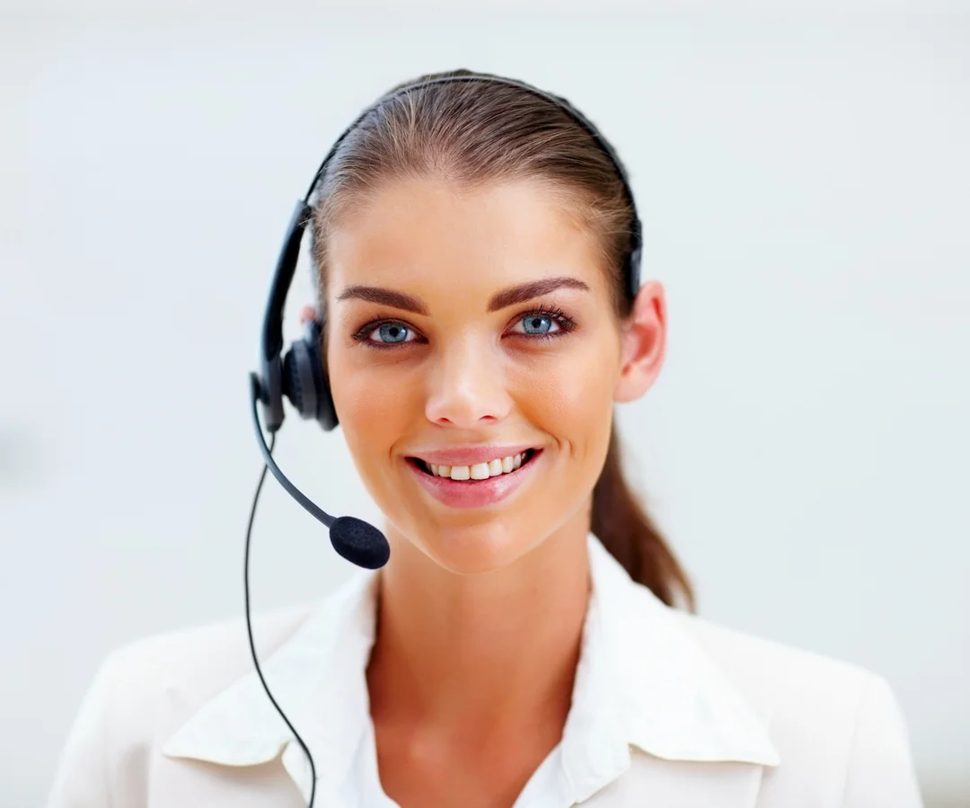Smiling woman wearing a headset against a soft blue background